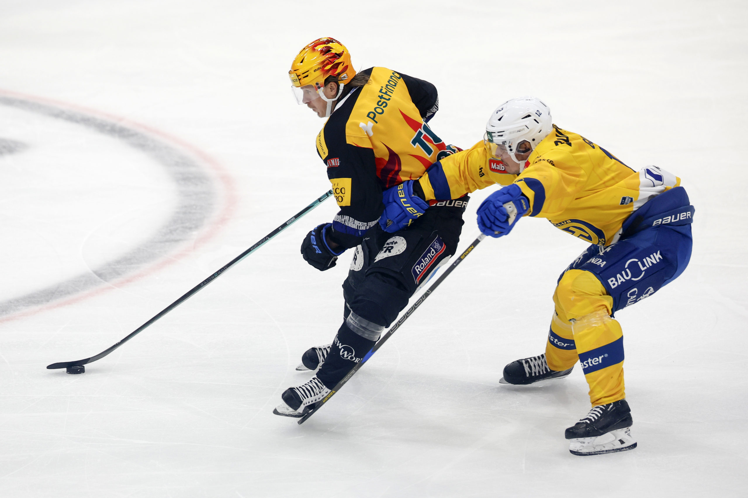 PostFinance Top Scorer Marcus Soerensen (HCFG) und Enzo Guebey (HCD) in Aktion im Eishockey Meisterschaftsspiel der National League zwischen dem HC Fribourg Gotteron und dem HC Davos, am Sonntag, 7. Dezember 2025 in der BCF-Arena in Fribourg. (PostFinance/KEYSTONE/Peter Klaunzer)